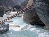 202 Log Across Miristi Khola �A few minutes later we were all assembled on the banks of the Miristi Khola, a turbulent river that drains all the waters from the upper basins of Annapurna, the Great Barrier and the Nilgiris. From now on the route lay along the opposite bank, so we had to cross over� (Maurice Herzog, Annapurna). The boys found an old log with some two or three inch stumps sticking out put laid it cross the river. It tilted downward at an angle of about 20 degrees, about 10 feet above the river.